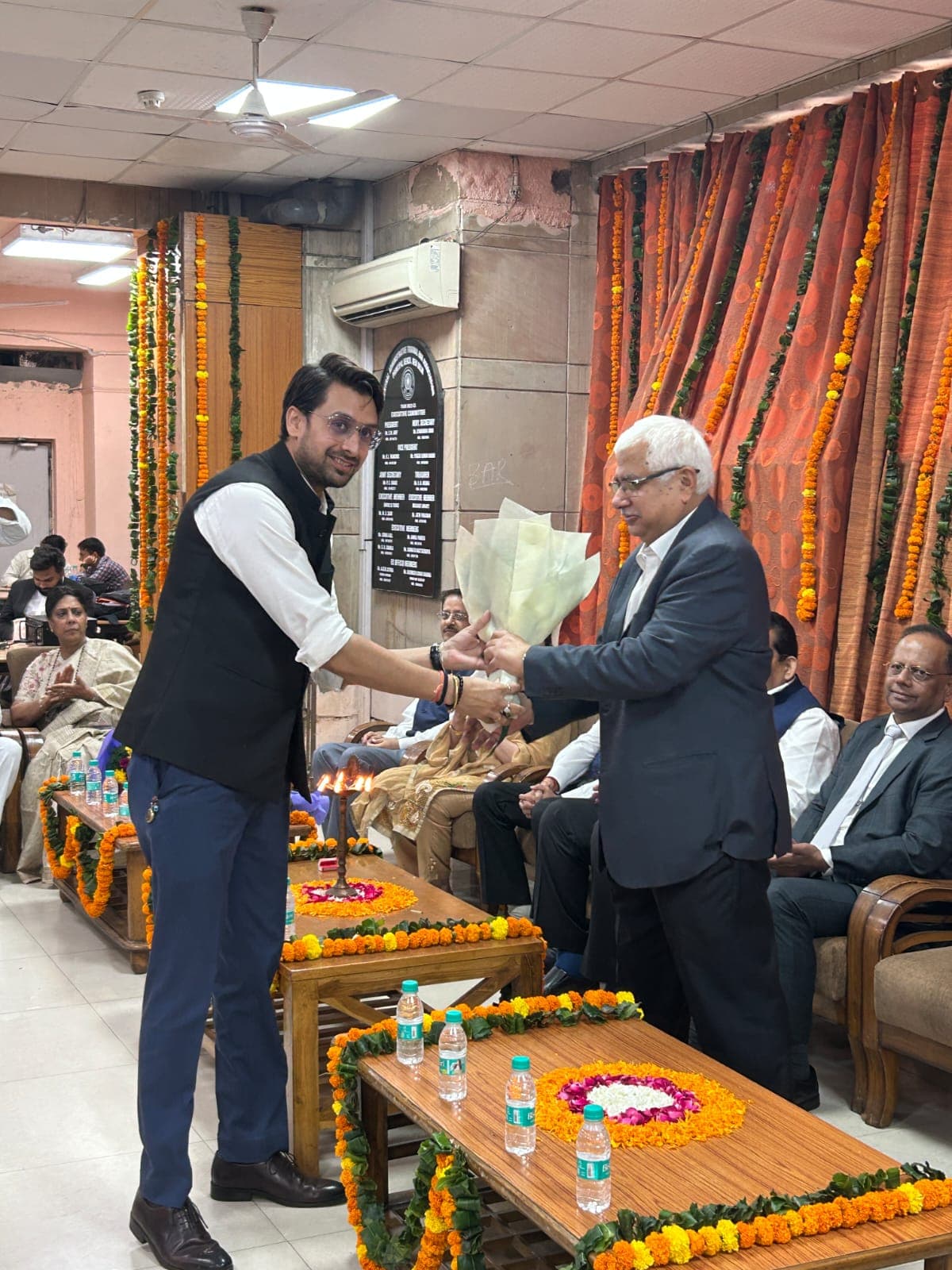 Jatin Parashar presenting a bouquet at a felicitation ceremony