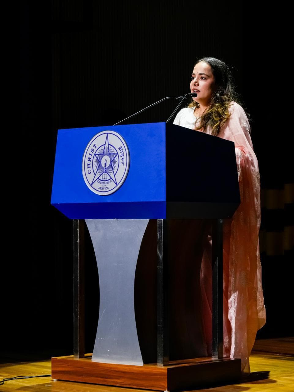 Gunjan Singh speaking at the podium, Prayaan '25 inaugural ceremony